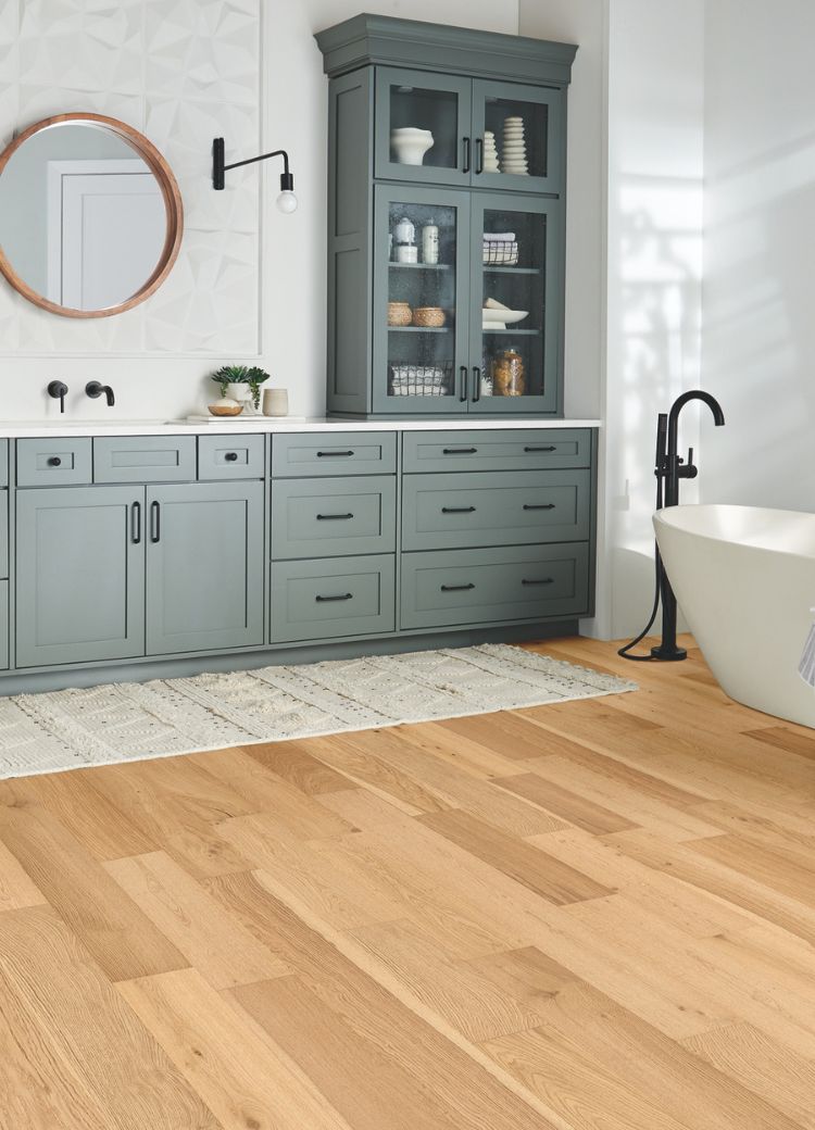 waterproof wood look flooring in a stylish bathroom with grey cabinets and tub