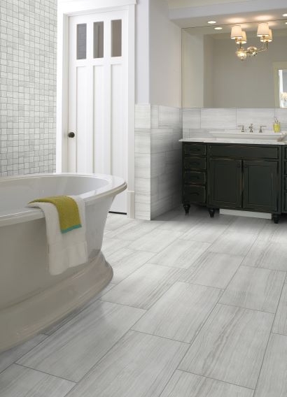 soft wood look tile flooring in a bright bathroom with mosaic tile accent wall
