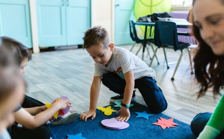 kids playing in classroom on carpet