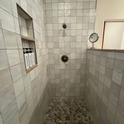 custom square shower tiles with half wall, niche, and shower tile floor