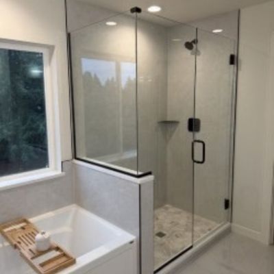clear glass shower door with shower tile floors and tub