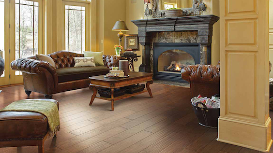 dark stained hardwood flooring in a classic living room with a fire place and leather couches